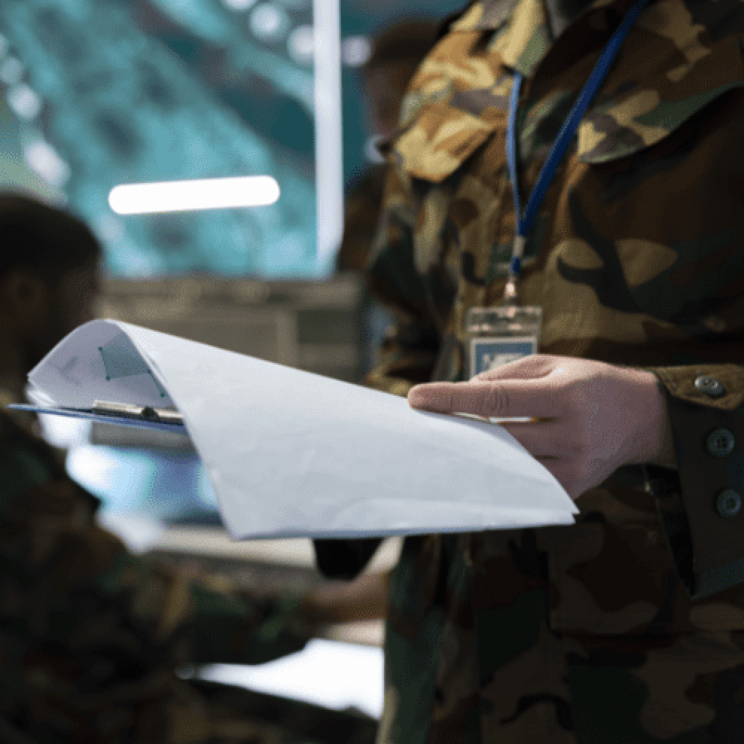 Oficial do exercito em pé folheando prancheta