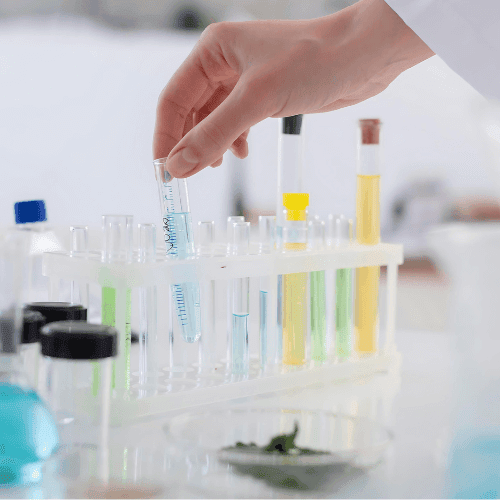 Mão segurando tubos de ensaio com produtos químicos
